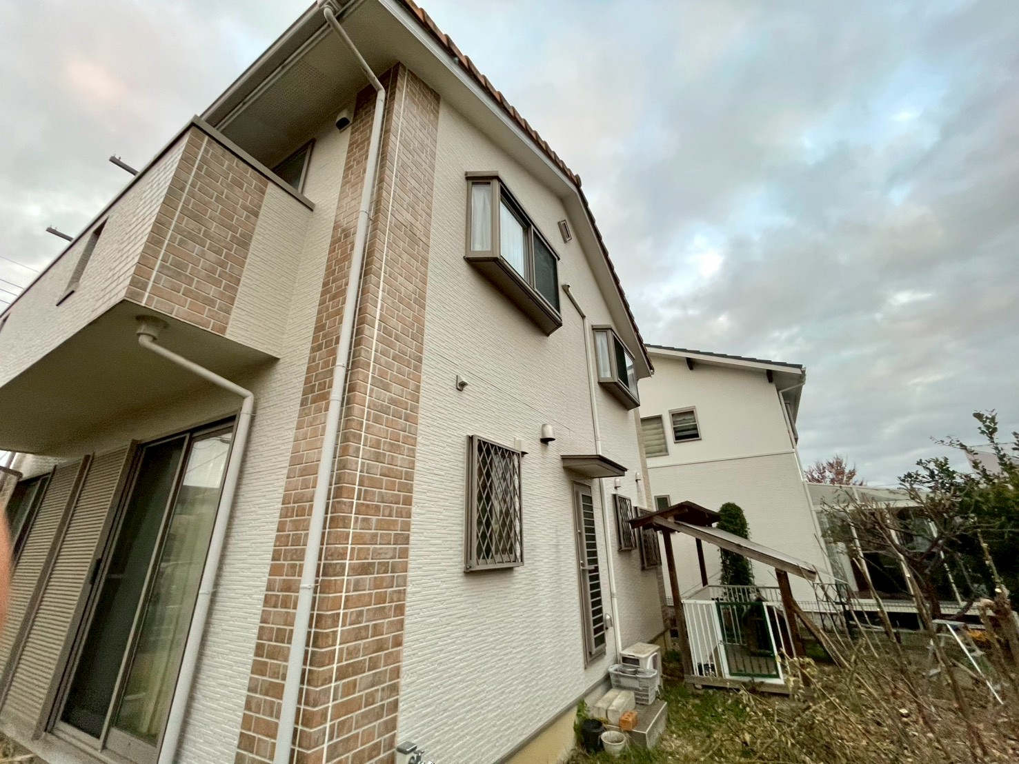 白と石目調のサイディング外壁